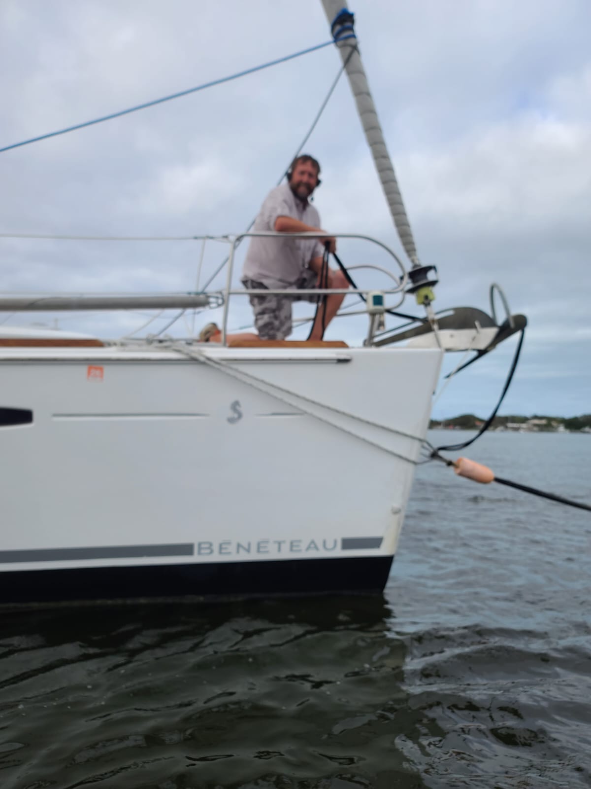 2Talk Marriage Savers communication headsets being worn by a boat crew member. The sailor is on the bow of the boat wearing the headset and talking to the captain at the helm.